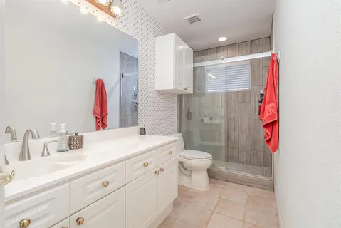 a bathroom with a sink a toilet and shower