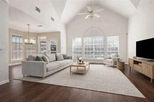 a living room with furniture a flat screen tv and a large window