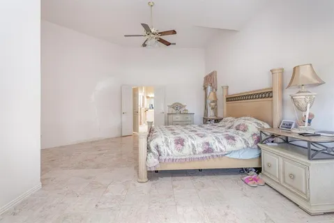 a bedroom with a bed and ceiling fan