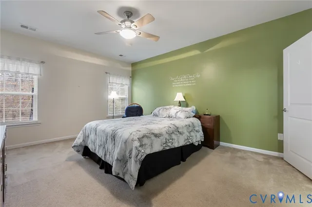 a spacious bedroom with a bed and a chandelier