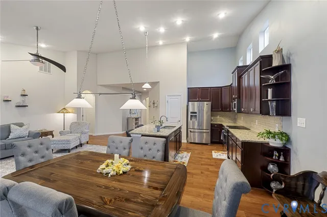 a living room with furniture kitchen view and a wooden floor