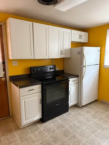 a kitchen with a refrigerator sink and cabinets