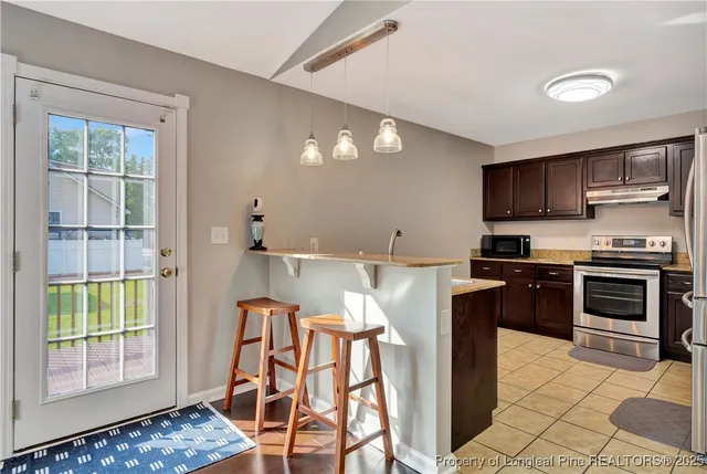 a kitchen with stainless steel appliances granite countertop a stove a sink and a microwave