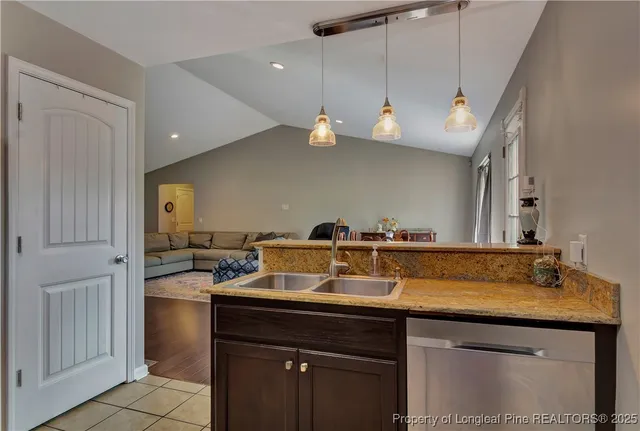 a kitchen with a sink a counter space appliances and cabinets