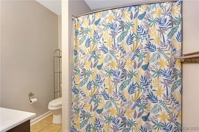a bathroom with a toilet and a shower curtain