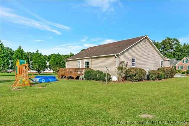 a front view of a house with garden and trees