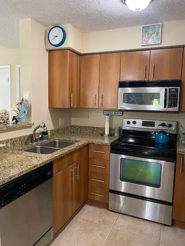 a kitchen with granite countertop a stove and a sink