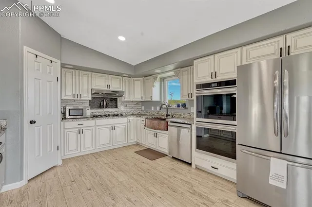 a kitchen with stainless steel appliances granite countertop a sink stove and cabinets