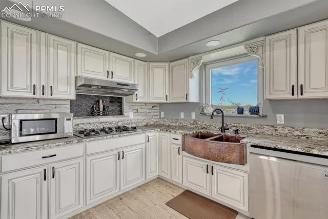 a kitchen with kitchen island granite countertop a sink stove and refrigerator