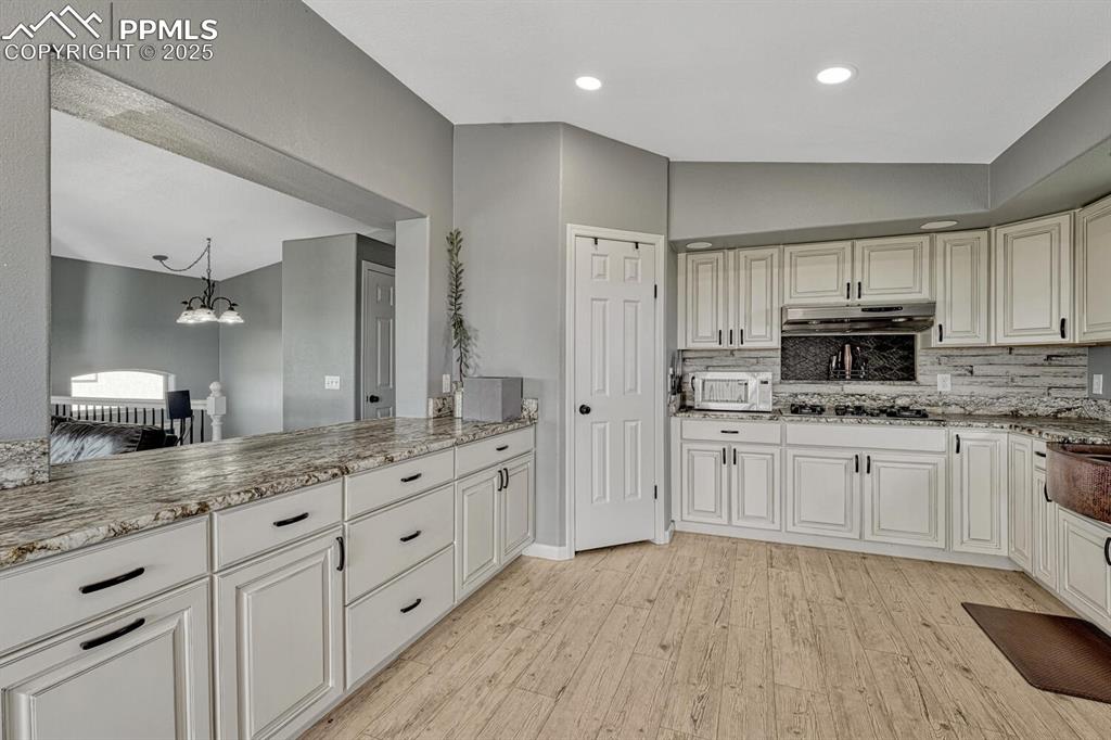 15371 Buck Creek Road Elbert, CO 80106 - Photo 7 of 50 a large kitchen with stainless steel appliances granite countertop a stove a sink and white cabinets