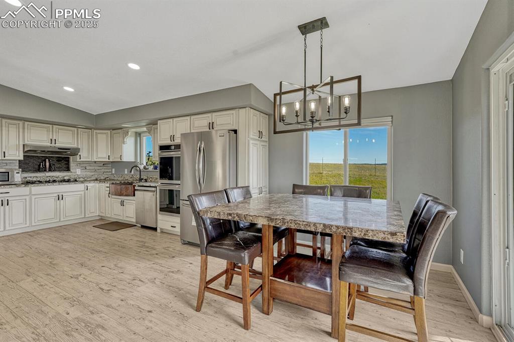 15371 Buck Creek Road Elbert, CO 80106 - Photo 8 of 50 a dining room filled chandelier and kitchen view