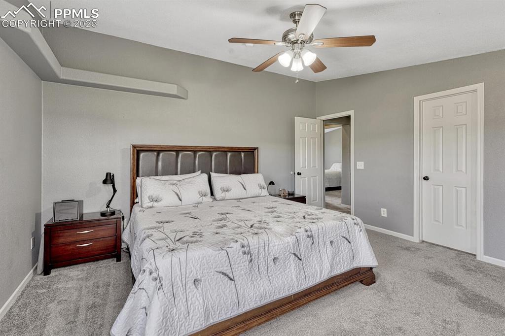 15371 Buck Creek Road Elbert, CO 80106 - Photo 10 of 50 a bedroom with a bed and a chandelier