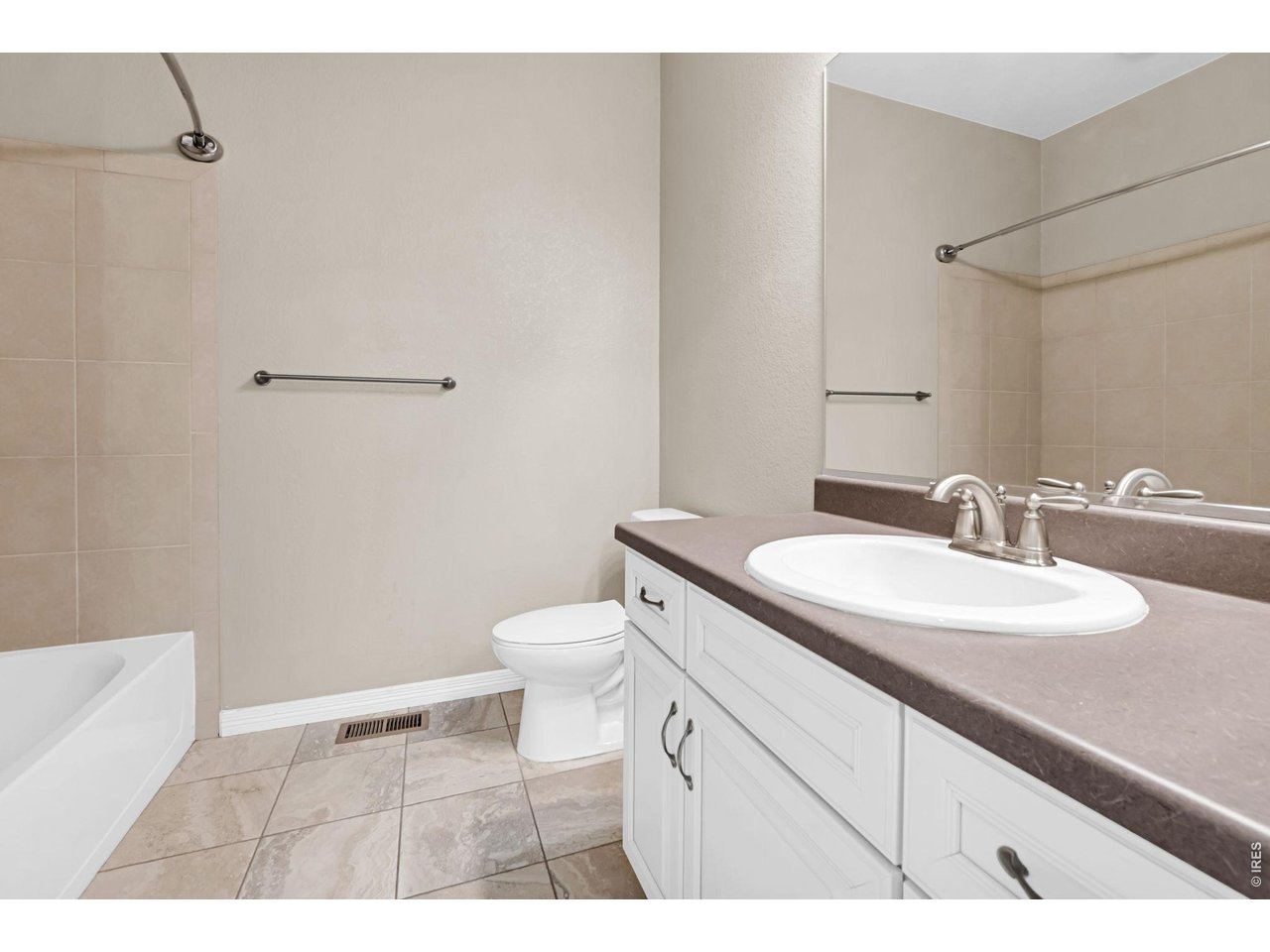 6028 Moran Road Timnath, CO 80547 - Photo 23 of 49 a bathroom with a granite countertop sink a toilet and a mirror