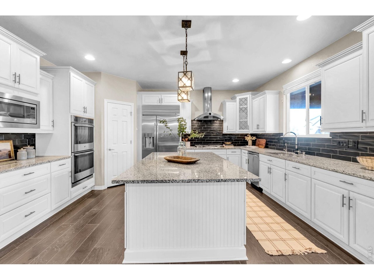 6028 Moran Road Timnath, CO 80547 - Photo 8 of 49 a kitchen with stainless steel appliances granite countertop a sink window and cabinets