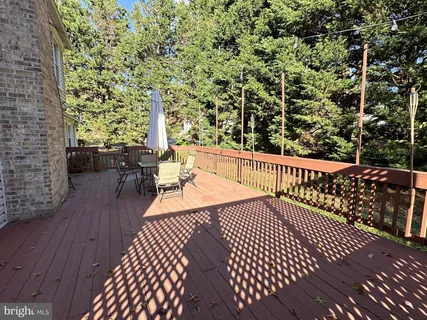 a balcony with wooden floor and outdoor seating