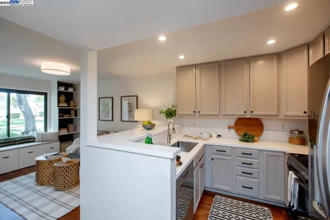 a kitchen with stainless steel appliances granite countertop a refrigerator and a stove top oven