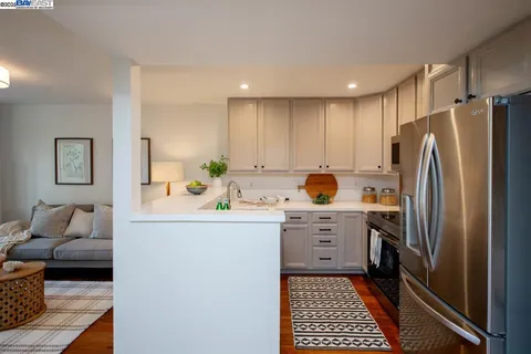 a living room with stainless steel appliances kitchen island granite countertop furniture and wooden floor