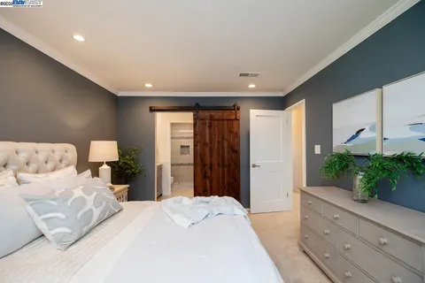 a bedroom with a bed and a flat tv screen on the dresser