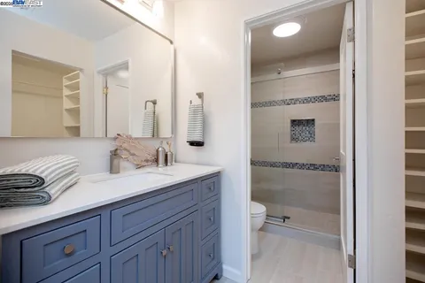 a bathroom with a granite countertop toilet sink and mirror