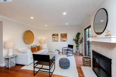 a living room with furniture a fireplace and a potted plant