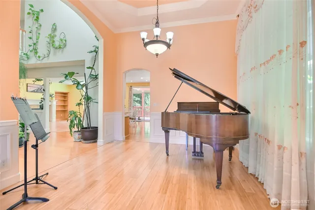 a kitchen with stainless steel appliances granite countertop a refrigerator a sink dishwasher a stove and a dining table with wooden floor