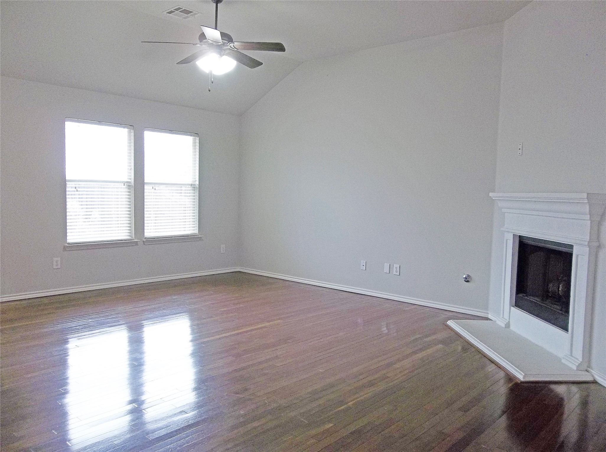 110 Fossil Trail Leander, TX 78641 - Photo 4 of 21 an empty room with wooden floor fireplace and windows