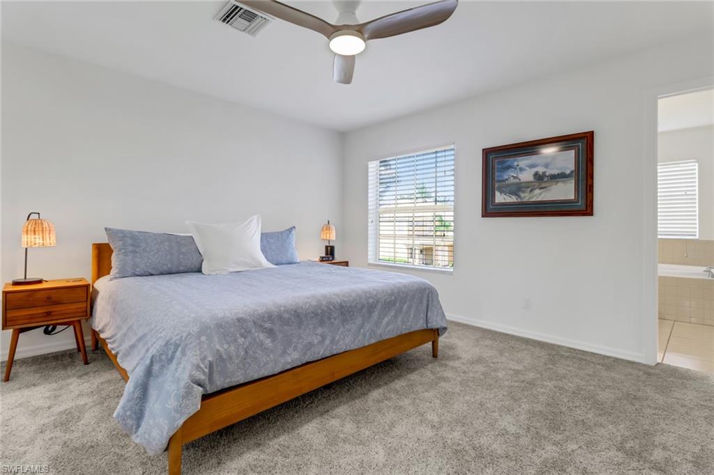 20024 Heatherstone Way, Unit 2 Estero, FL 33928 - Photo 14 of 38 a bedroom with a bed and a chandelier