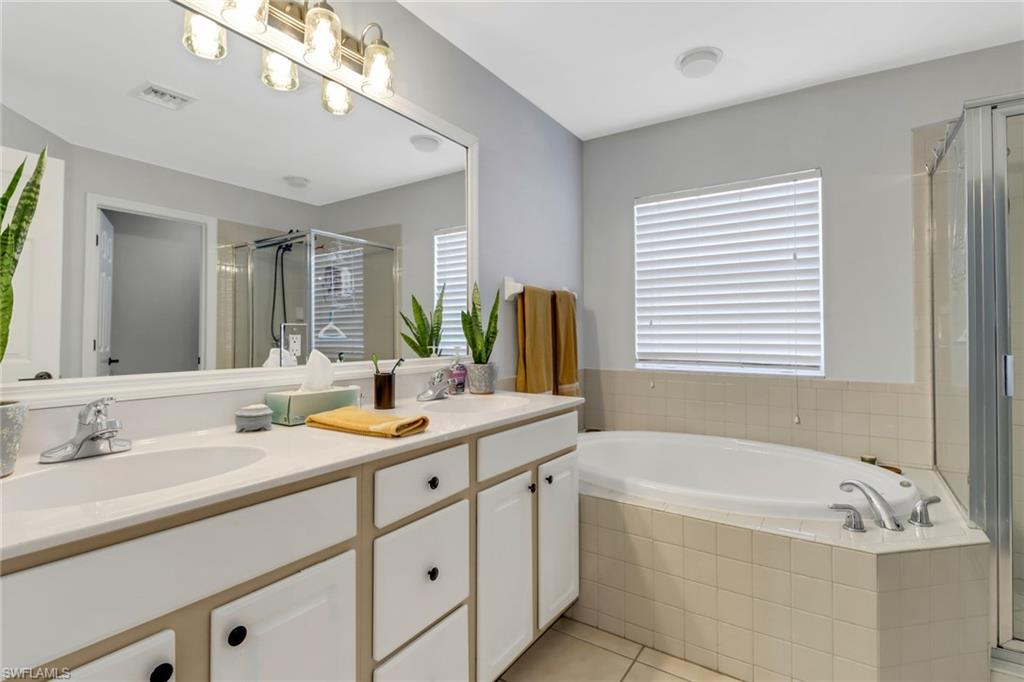 20024 Heatherstone Way, Unit 2 Estero, FL 33928 - Photo 17 of 38 a bathroom with a tub sink and mirror
