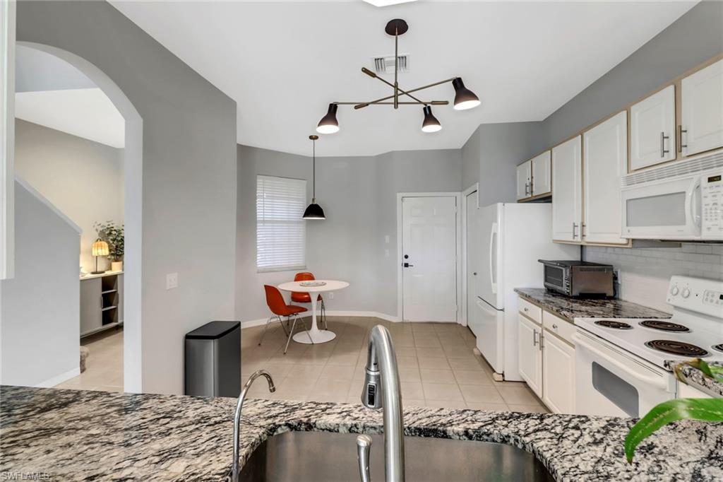 20024 Heatherstone Way, Unit 2 Estero, FL 33928 - Photo 6 of 38 a kitchen with stainless steel appliances granite countertop a sink stove and refrigerator