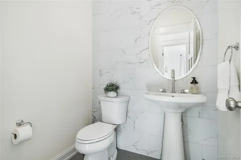 a bathroom with a sink a toilet and a mirror
