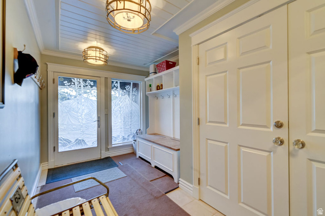 9699 Bypass Road, Unit 5 Alta, UT 84092 - Photo 3 of 54 Entryway featuring a white paneled door with etched glass, a wood-finish bench, and built-in storage with coat hooks