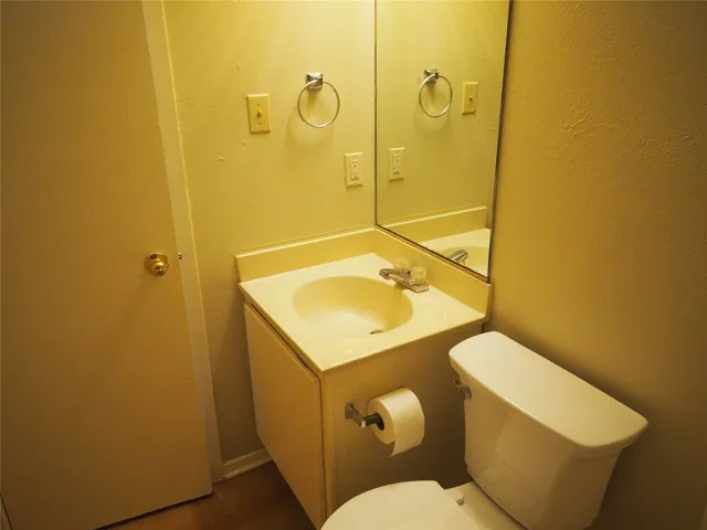a bathroom with a sink mirror vanity and toilet