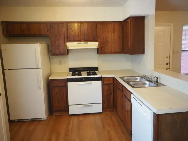 a kitchen with a refrigerator a stove a sink and cabinets