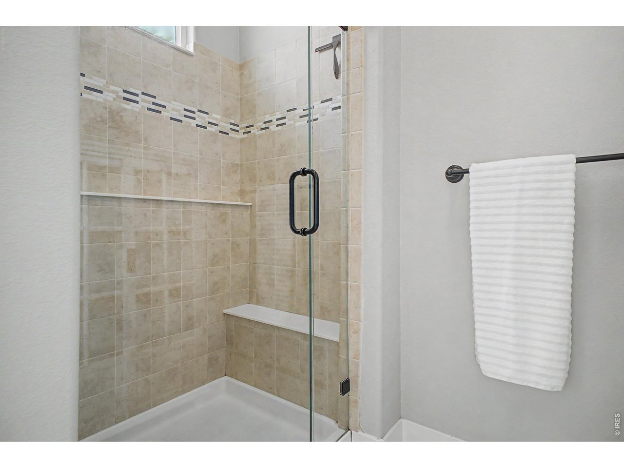 2069 Day Spring Drive Windsor, CO 80550 - Photo 16 of 47 Fully tiled shower with bench, large glass door and natural light