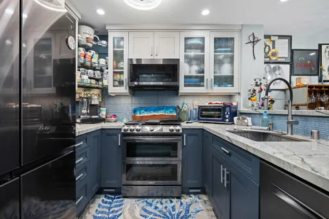 a kitchen with stainless steel appliances granite countertop a refrigerator and a sink