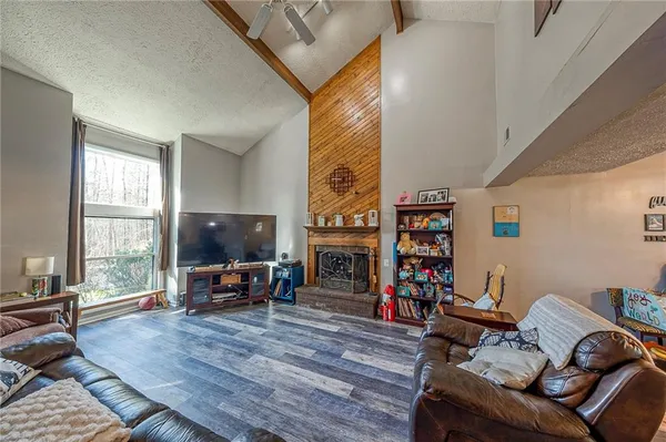 a living room with furniture a fireplace and a large window