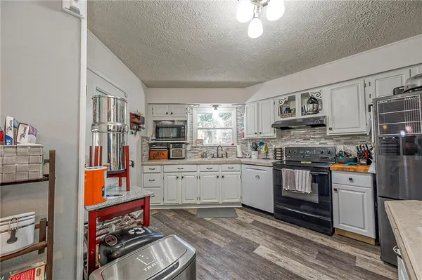 a kitchen with stainless steel appliances granite countertop a stove refrigerator and cabinets