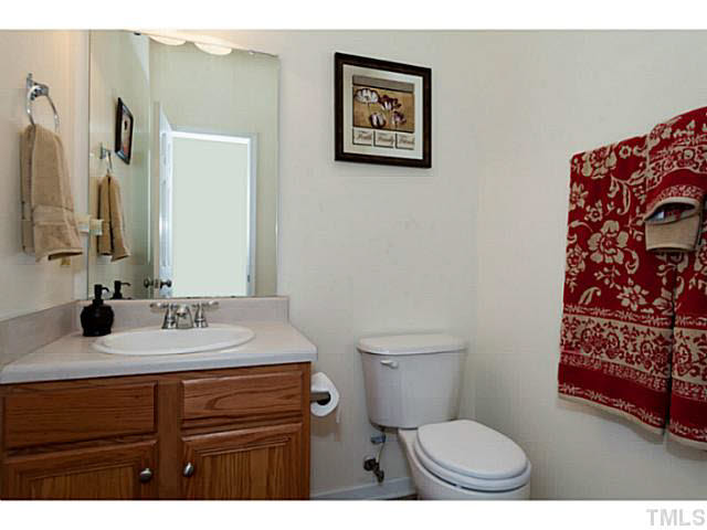 8424 Ridgebury Road Raleigh, NC 27603 - Photo 13 of 25 a bathroom with a toilet a sink and a mirror