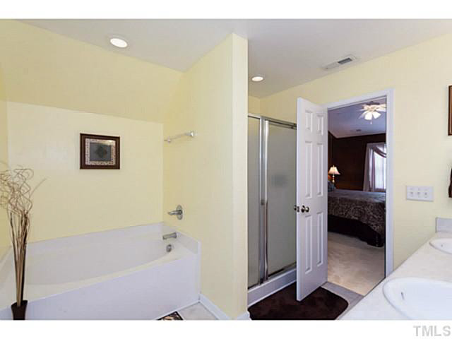 8424 Ridgebury Road Raleigh, NC 27603 - Photo 18 of 25 a bathroom with a bathtub and a shower
