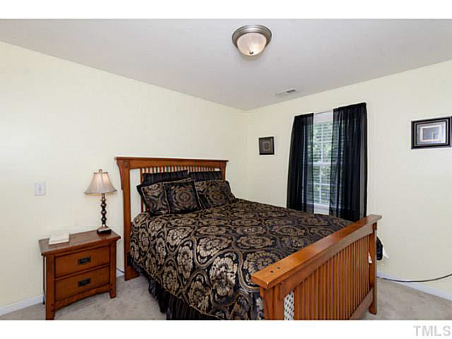 8424 Ridgebury Road Raleigh, NC 27603 - Photo 22 of 25 a bedroom with a bed and a dresser