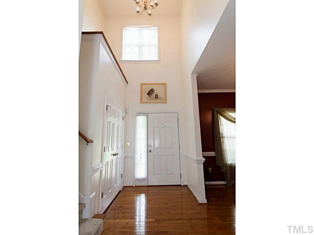 8424 Ridgebury Road Raleigh, NC 27603 - Photo 3 of 25 a view of a hallway with wooden floor and a bathroom