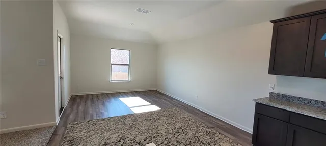 an empty room with a fireplace and wooden floor