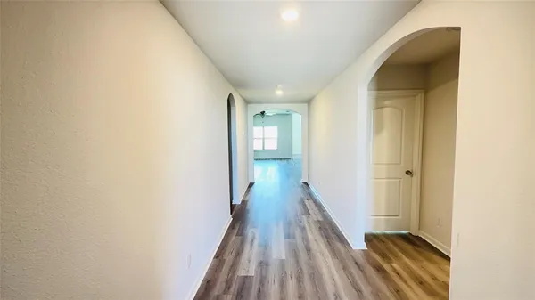 a view of a hallway with wooden floor and staircase