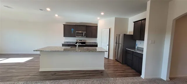 a kitchen with stainless steel appliances granite countertop a refrigerator and a stove