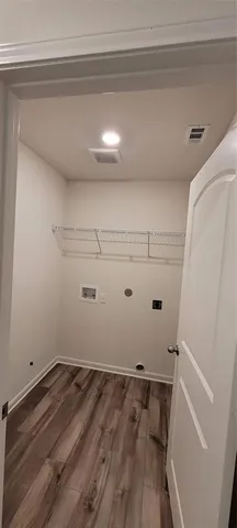 a view of a room with wooden floor and white walls