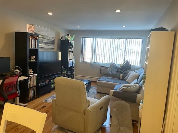 a living room with furniture a flat screen tv and a window