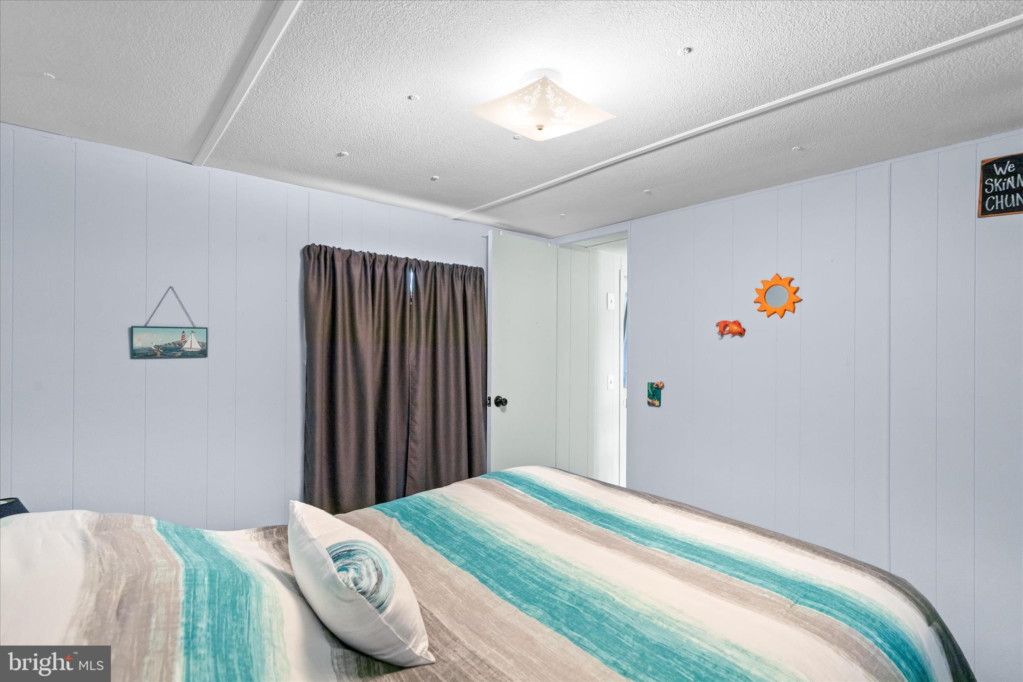 38215 Possum Road Ocean View, DE 19970 - Photo 23 of 26 a bedroom with a bed and a chandelier