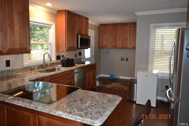 a kitchen with granite countertop a sink stove and refrigerator