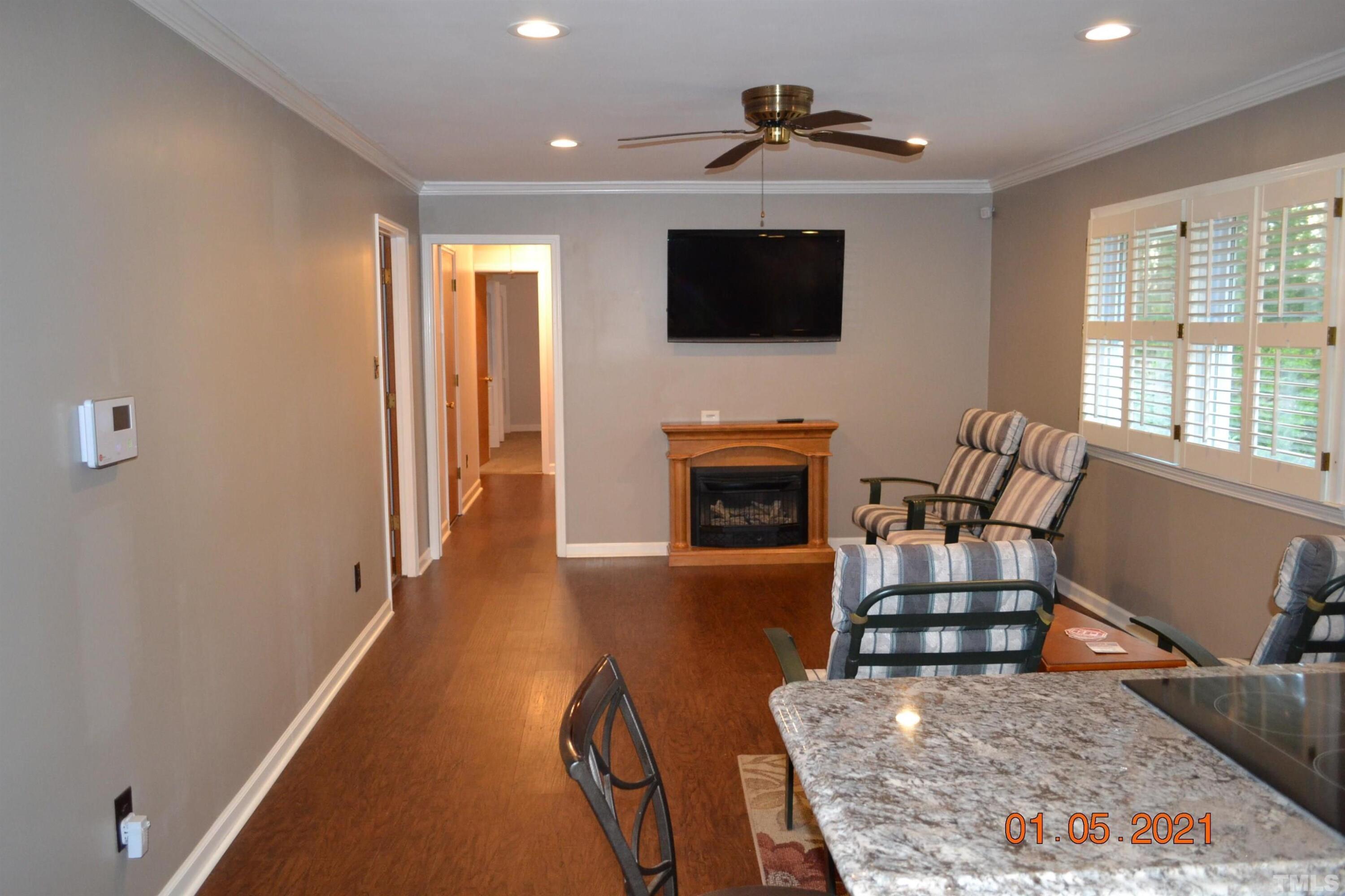 2015 Piney Plains Road Cary, NC 27518 - Photo 16 of 27 a living room with furniture a flat screen tv and a fireplace