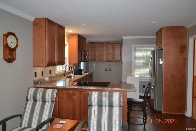 a kitchen with stainless steel appliances granite countertop a refrigerator and a sink